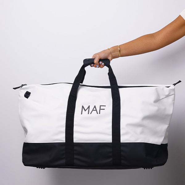 MEDIUM WHITE/BLACK DUFFLE BAG WITH SHOULDER STRAP - BLACK STRAP 69x26cm - 69x26cm حقيبة يد متوسطة الحجم باللون الأبيض/ الأسود مع حزام كتف - حزام أسود